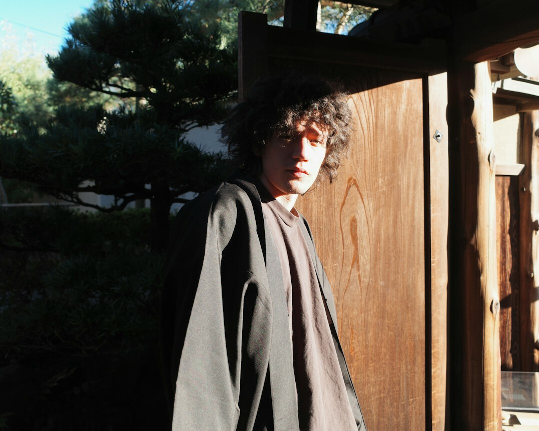 Japanese man with curly hair and glasses