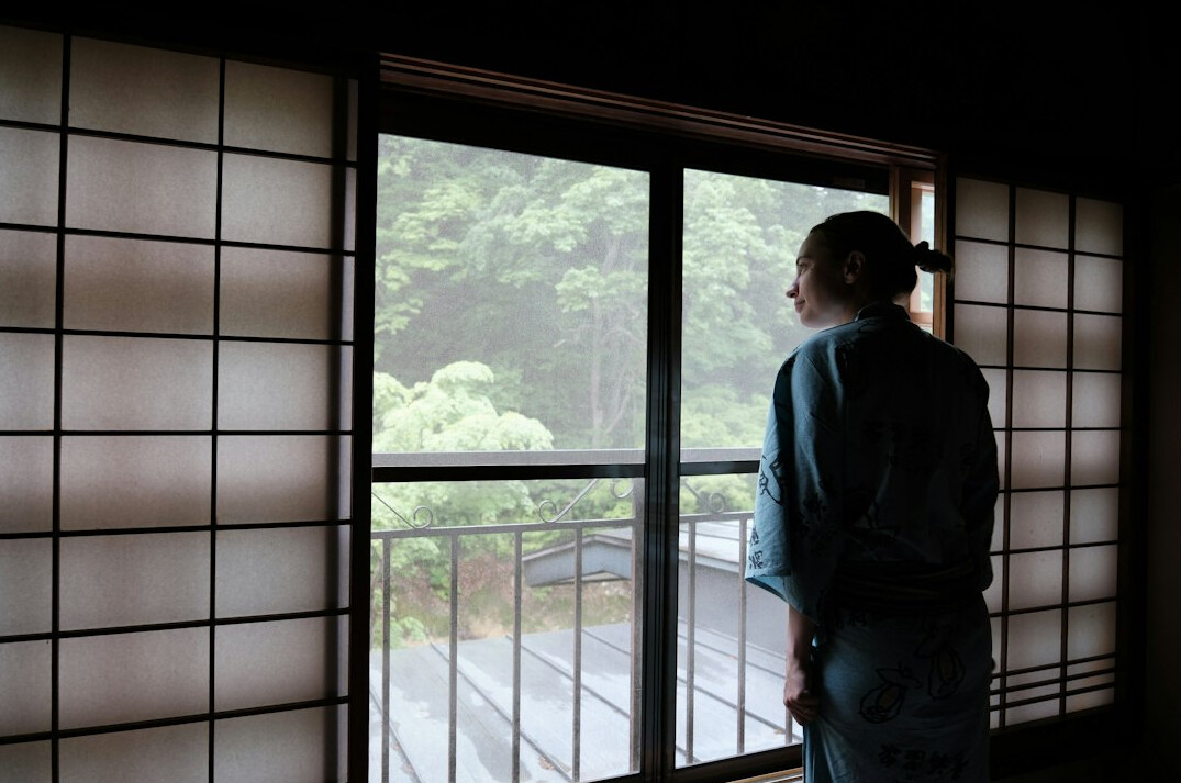 Japanese woman standing by a window
